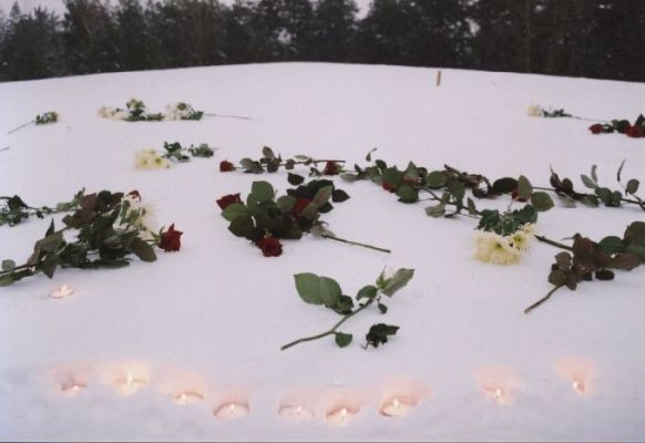 Flowers and burning candles at the mound of ashes to commemorate the victims.